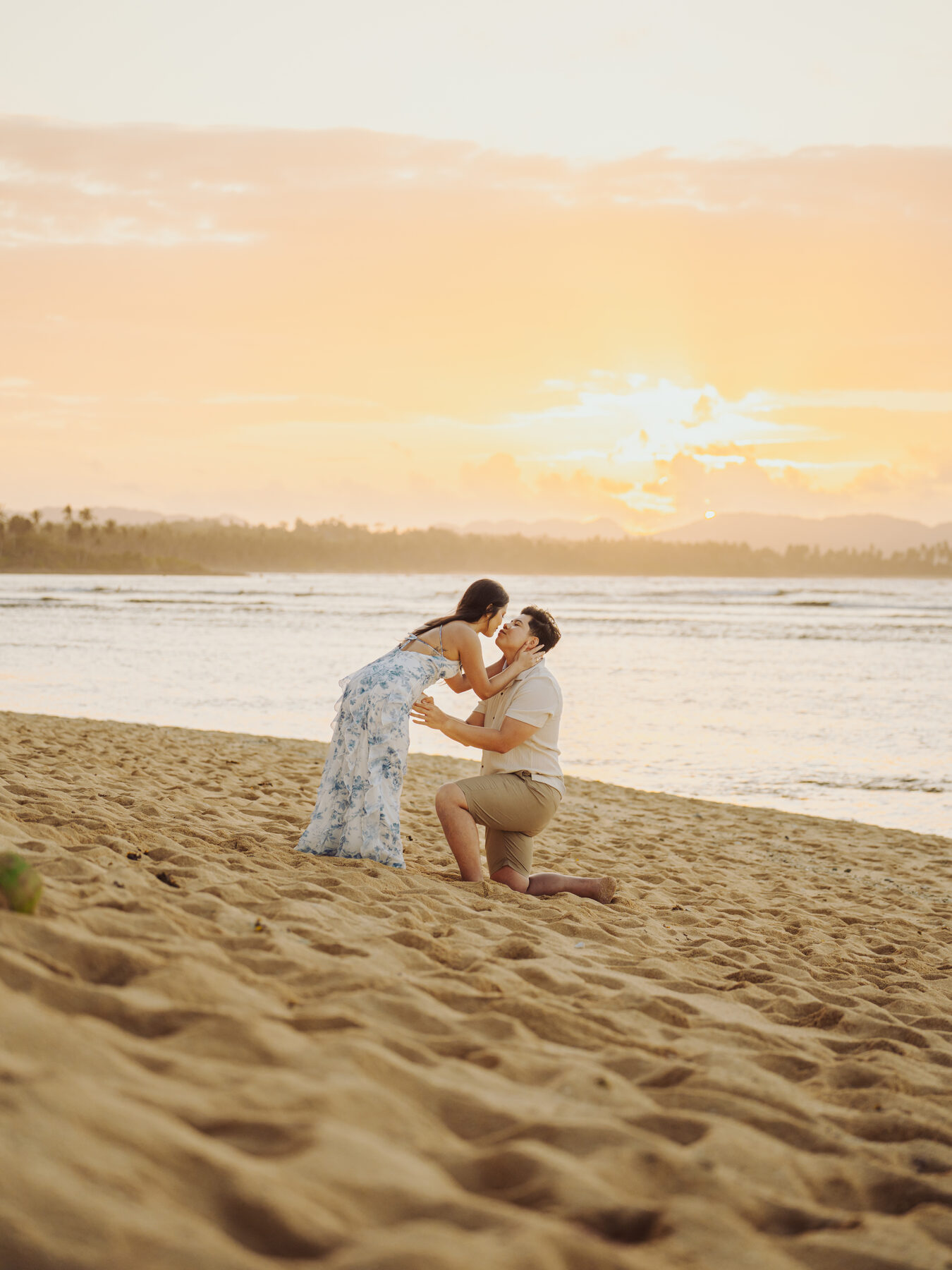 Anthony proposing to Angela on a quiet stretch of beach in Siargao, Philippines, at sunset.