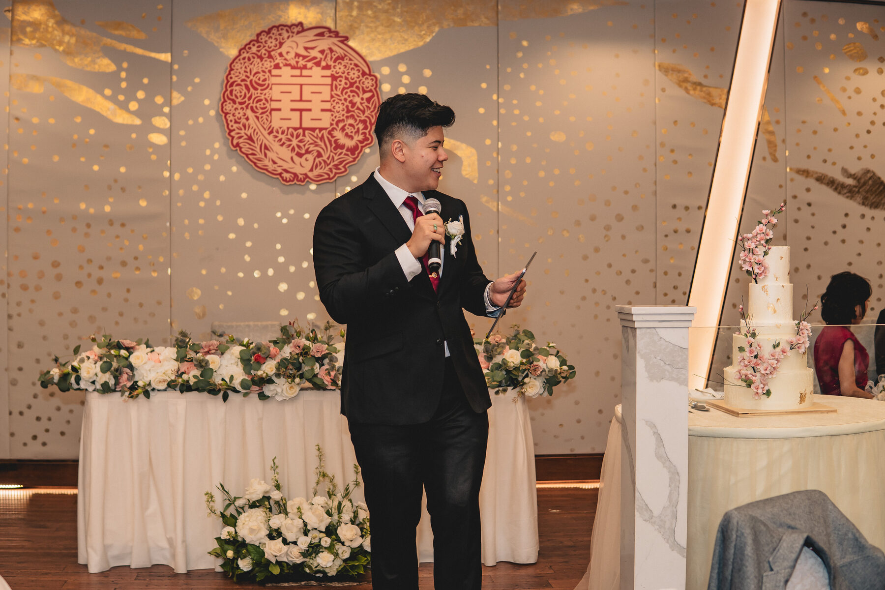 Anthony hosting, checking his notes, at Peter & Christine's Toronto reception.
