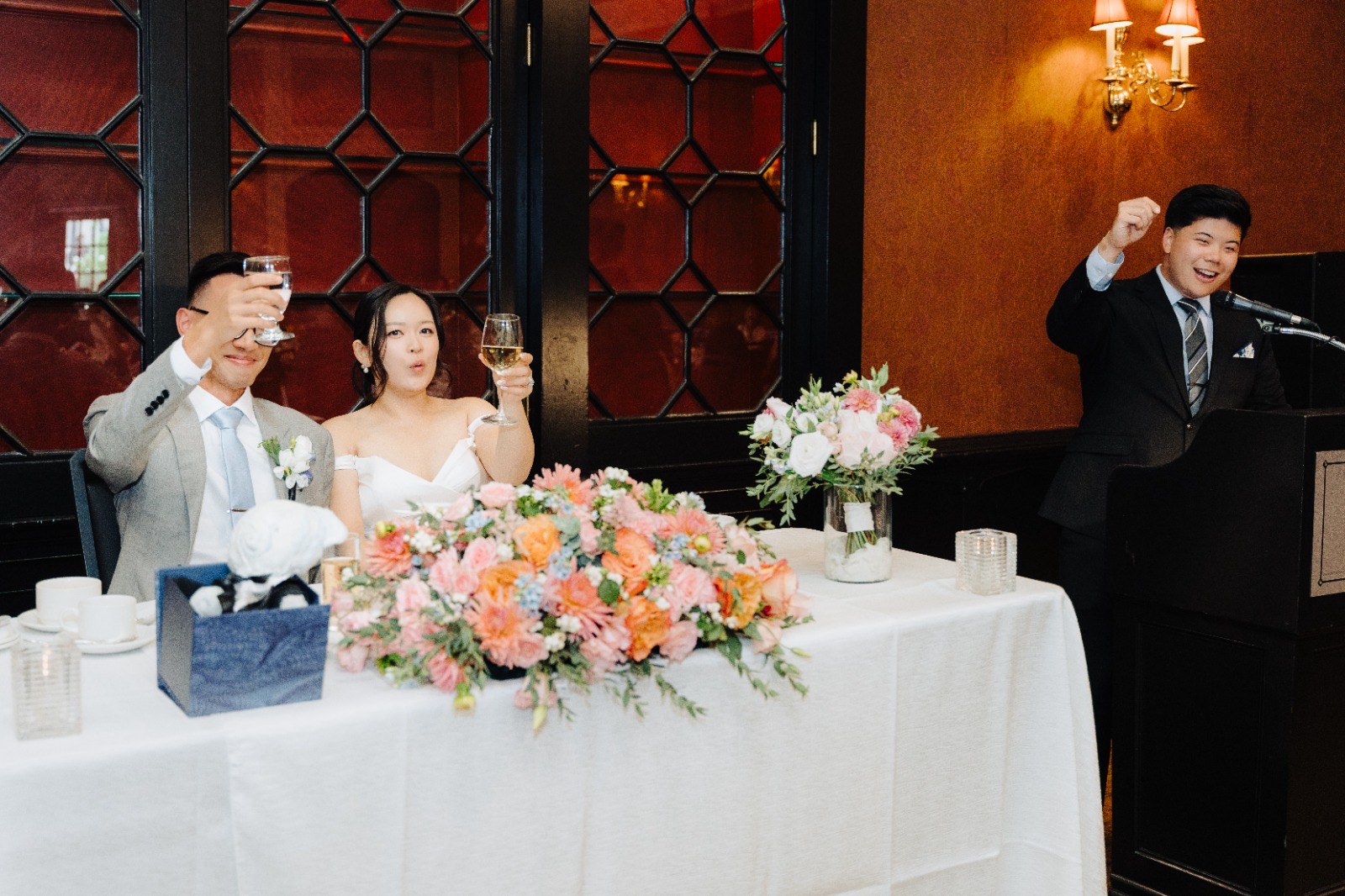 Steven and Esther smiling at the head table during speeches.