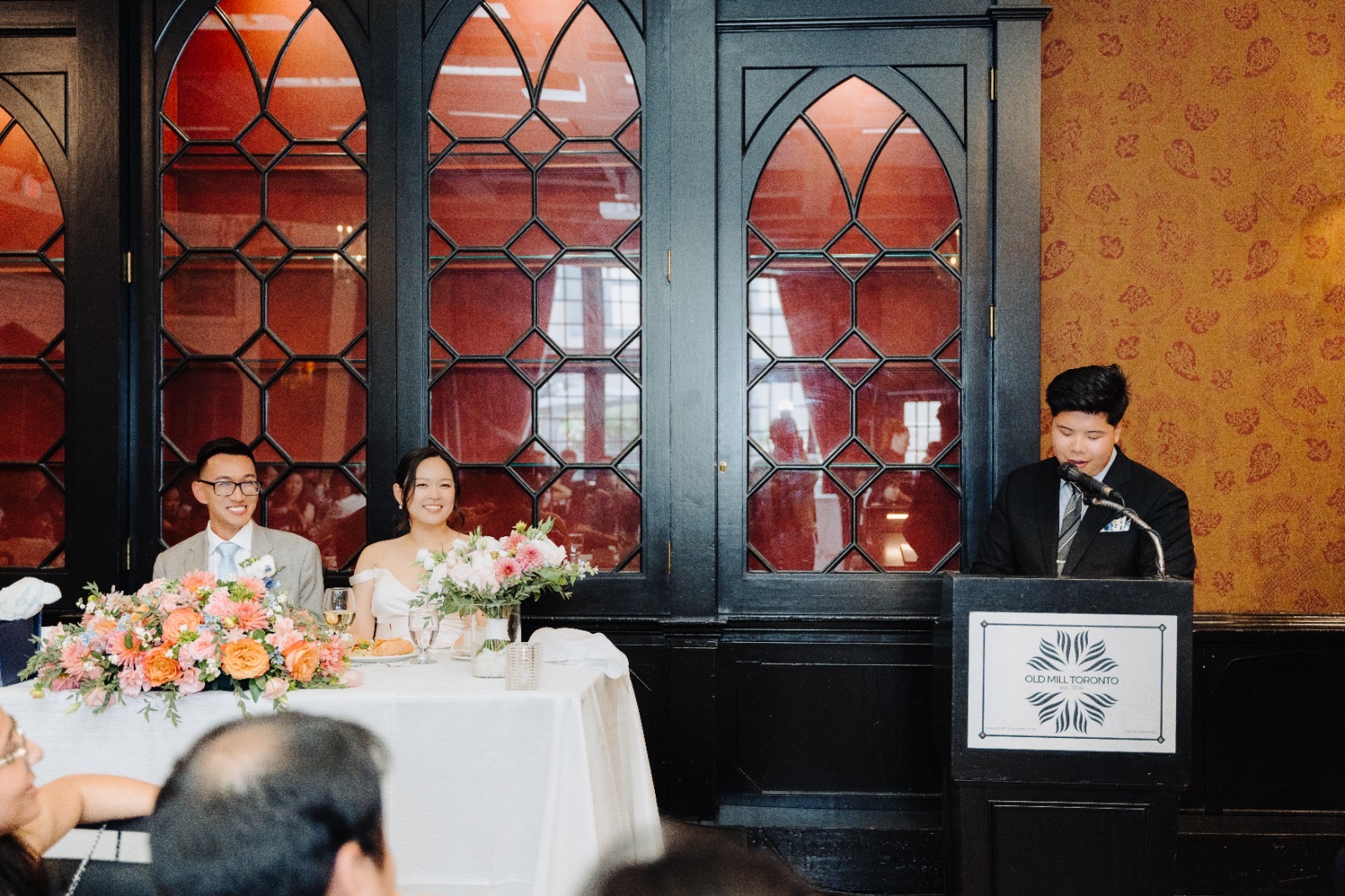 Anthony mid-speech with Steven and Esther smiling in the background.