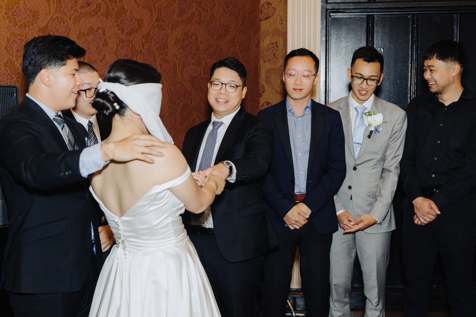 Steven and Esther playing a reception game with the wedding party looking on.
